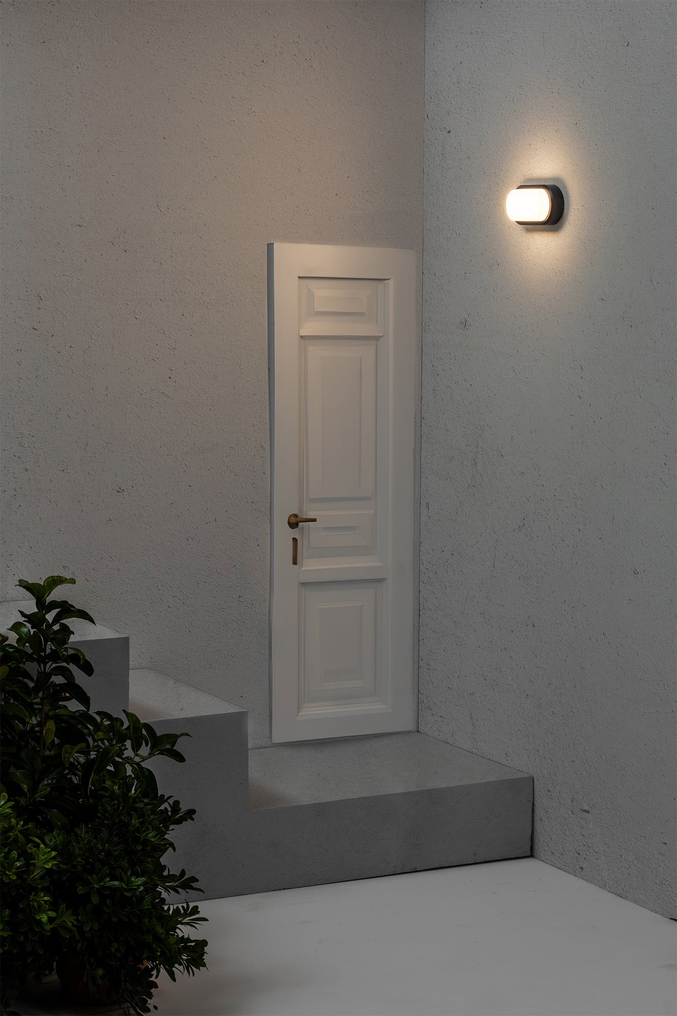 Lámpara de pared FRED 200 en gris oscuro de FARO (modelo 70663) instalada en terraza exterior, luminaria LED de superficie IP65 con iluminación cálida para exteriores