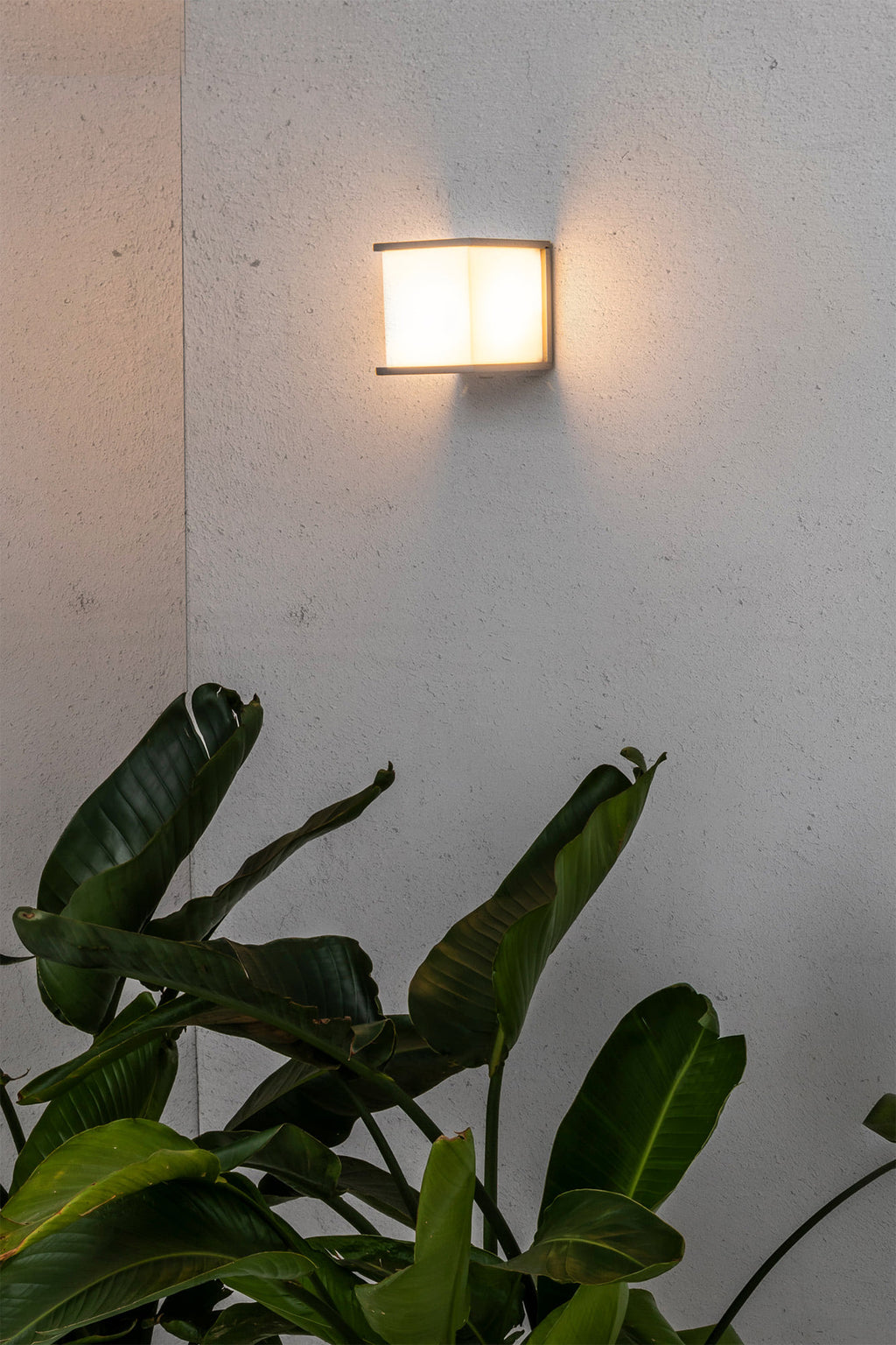 Aplique de pared exterior KUBICK Gris FARO 70715 en ambiente iluminado, luminaria superficie aluminio IP44 para iluminación exterior LED E27