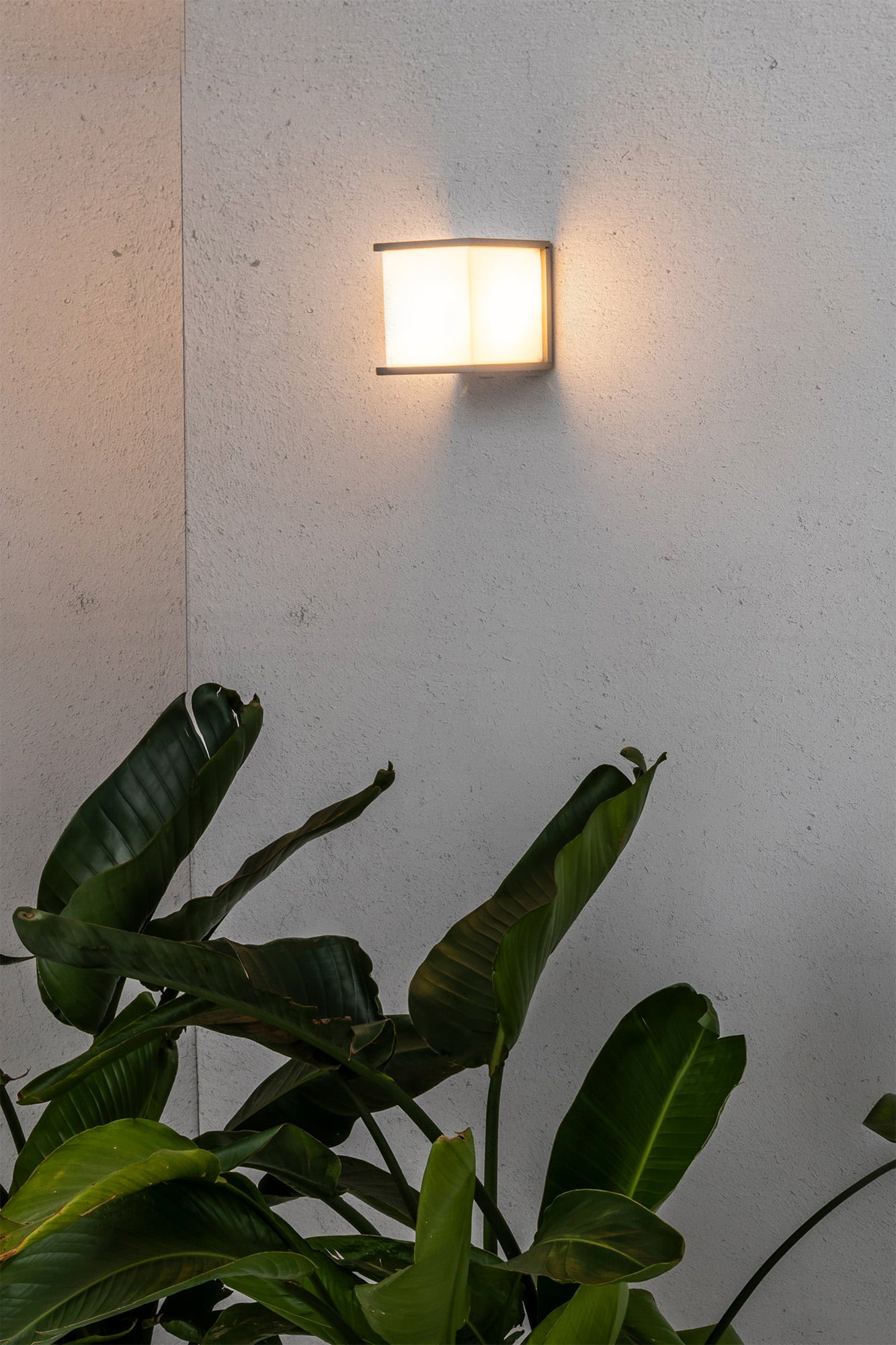 Aplique de pared exterior KUBICK Gris FARO 70715 en ambiente iluminado, luminaria superficie aluminio IP44 para iluminación exterior LED E27