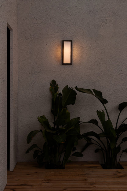 Lámpara de pared exterior MOL gris oscuro FARO 70720 en ambiente, luminaria superficie LED IP44 de aluminio y policarbonato serie 1367 instalada en pared exterior iluminando jardín nocturno