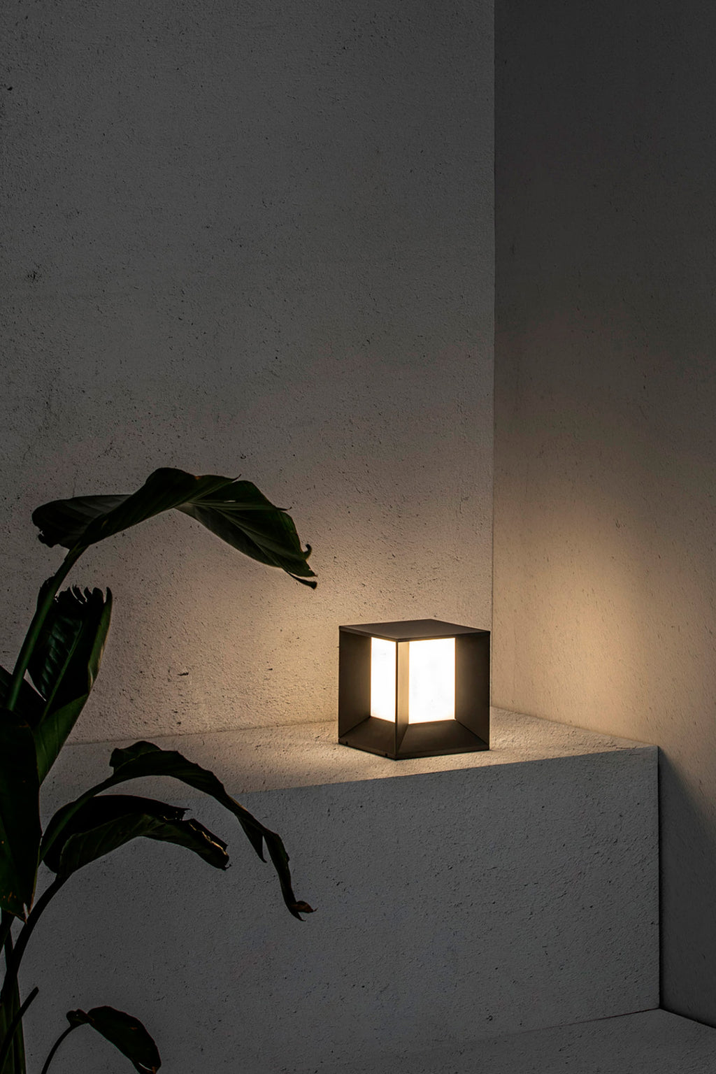Sobremuro LED Mila gris oscuro FARO 70771 en ambiente exterior de jardín, luminaria superficie de aluminio IP65 con luz natural para iluminación jardín