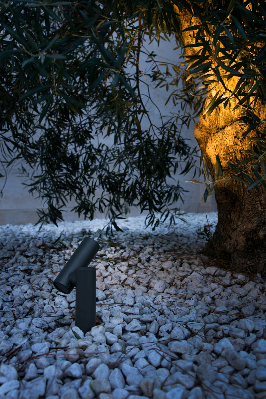 Luminaria sobremuro SPY 145 gris oscuro FARO 70782 instalada en jardín exterior, iluminación LED IP65 de aluminio para patios y terrazas