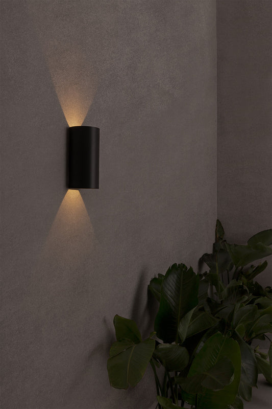 Luminaria de pared LED BRUC en gris oscuro de FARO (70828), instalada en jardín exterior contemporáneo, iluminación LED en aluminio IP54 para exteriores