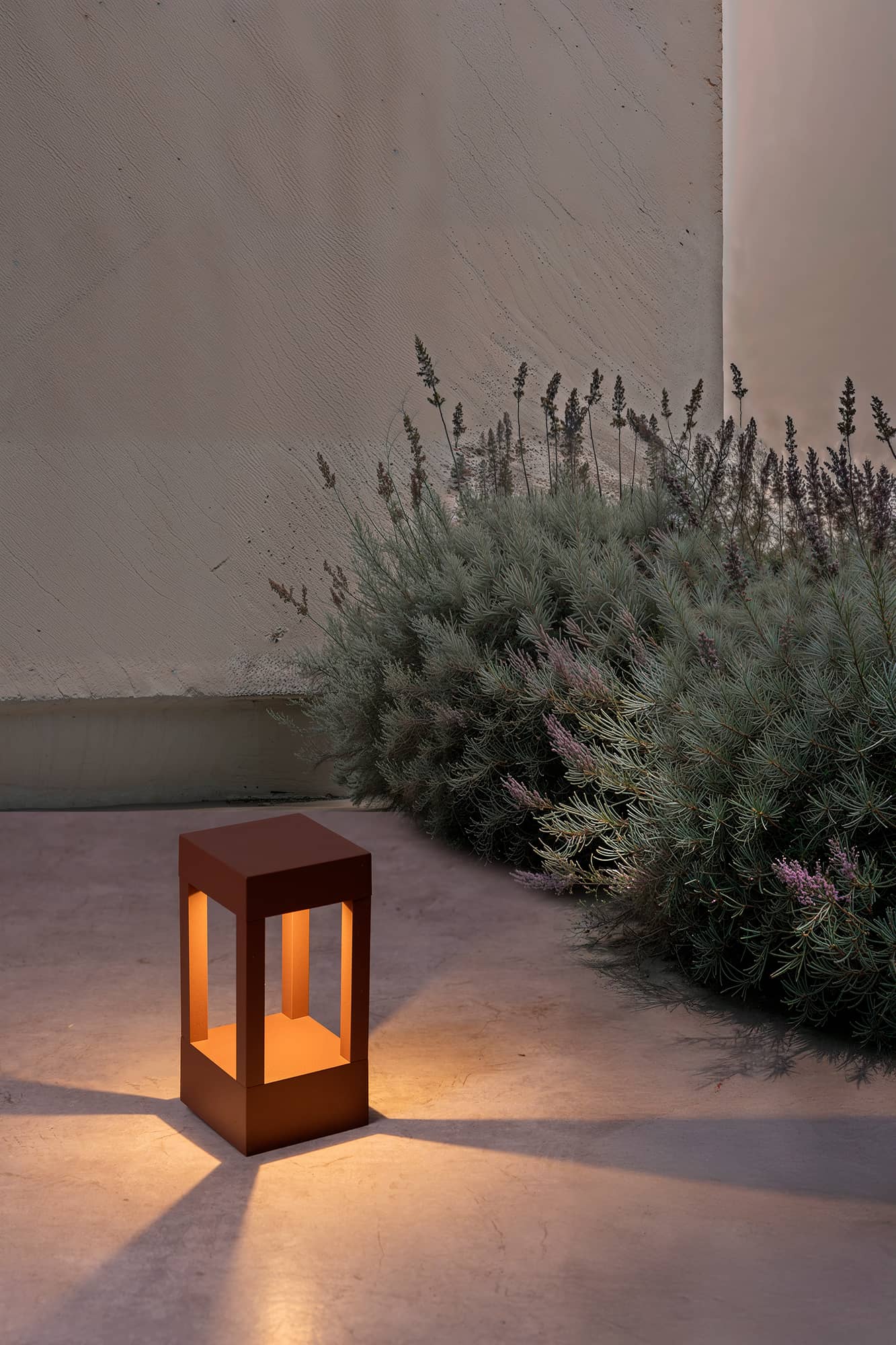 Baliza exterior AGRA 200 en color marrón con luz LED cálida 2700K iluminando jardín nocturno, faro decorativo IP55 para luminaria superficie en exteriores