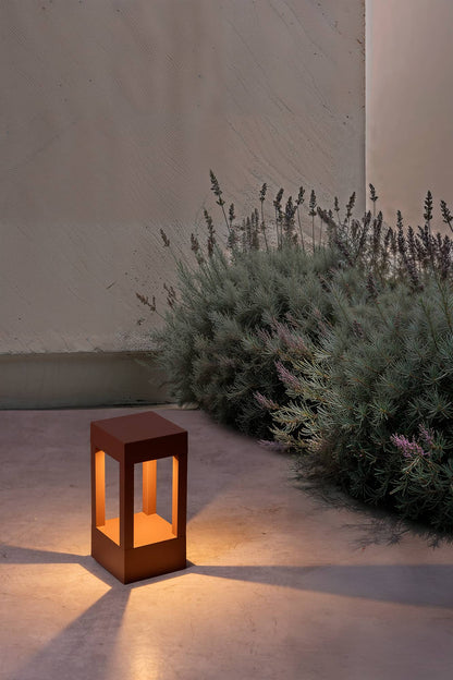 Baliza exterior AGRA 200 en color marrón con luz LED cálida 2700K iluminando jardín nocturno, faro decorativo IP55 para luminaria superficie en exteriores