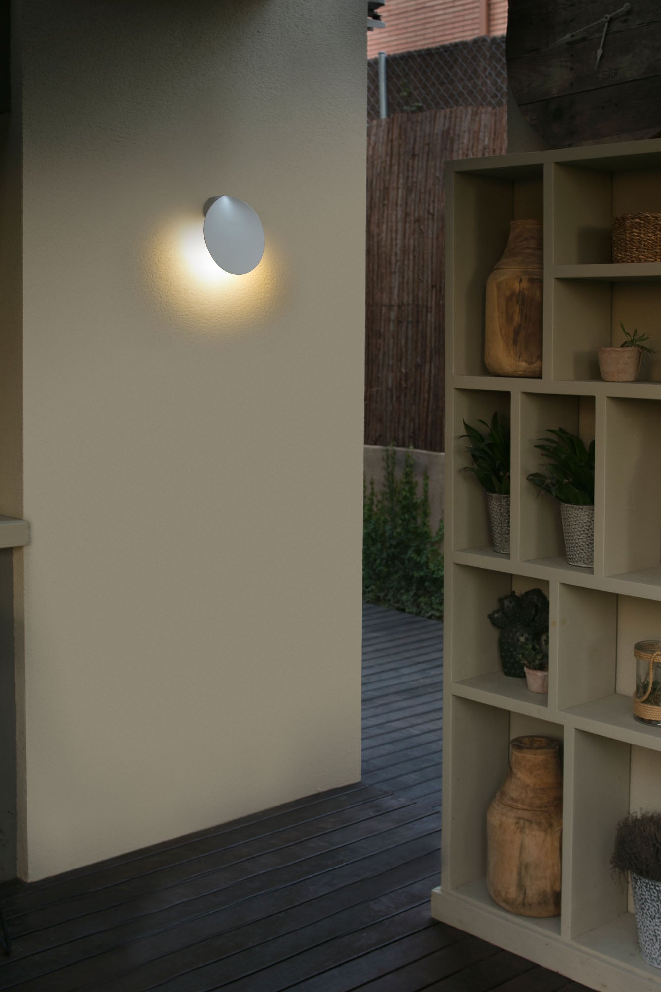 Aplique de pared exterior Lotus blanco de Faro (modelo 71222) en ambiente de jardín iluminado, diseño LED en aluminio IP65 para terraza