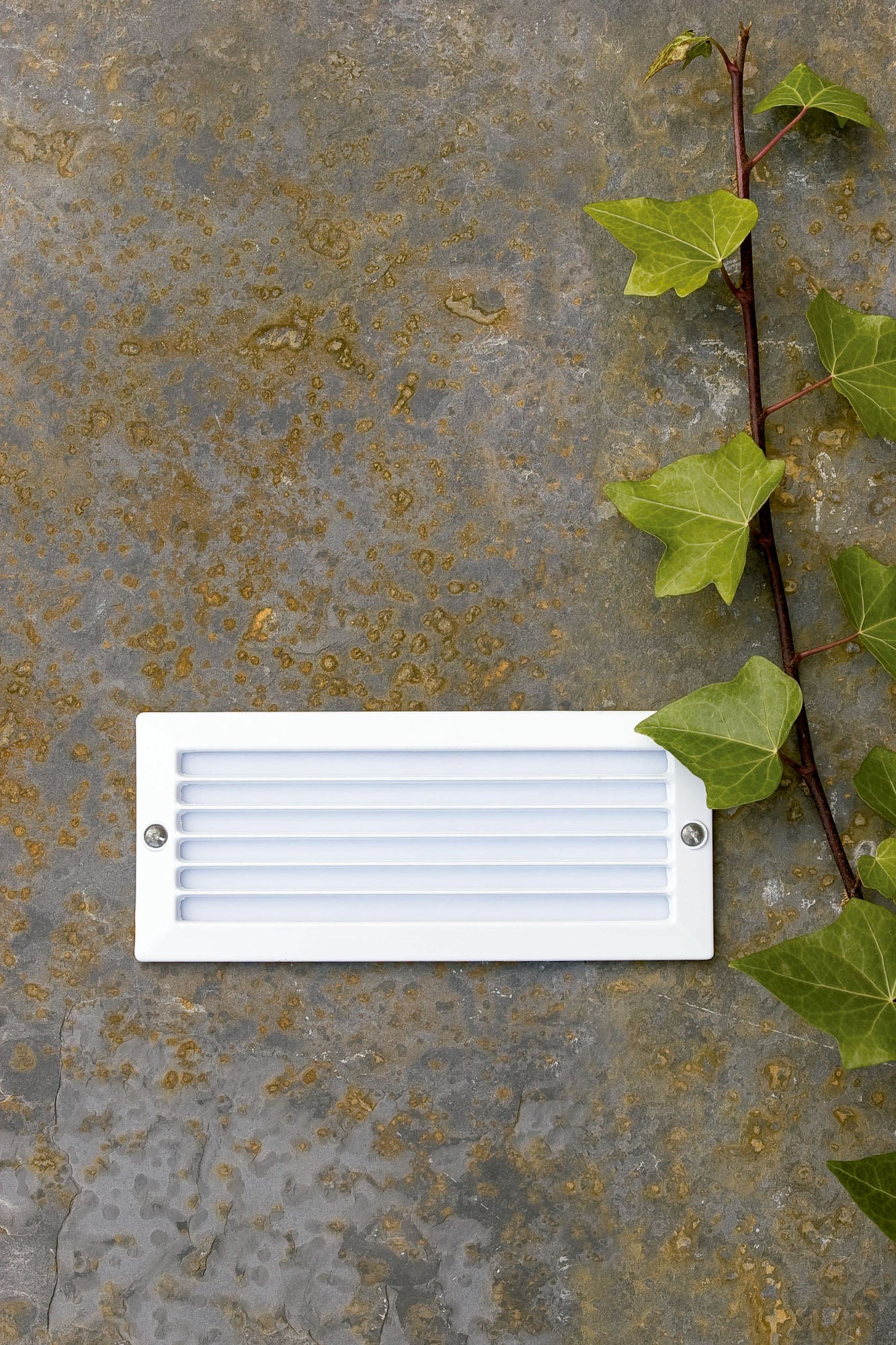 Luz empotrable ESCA blanco FARO 71480 en ambiente exterior, instalada en pared con diseño en aluminio y cristal, iluminación LED E27 IP44 de la colección 206.