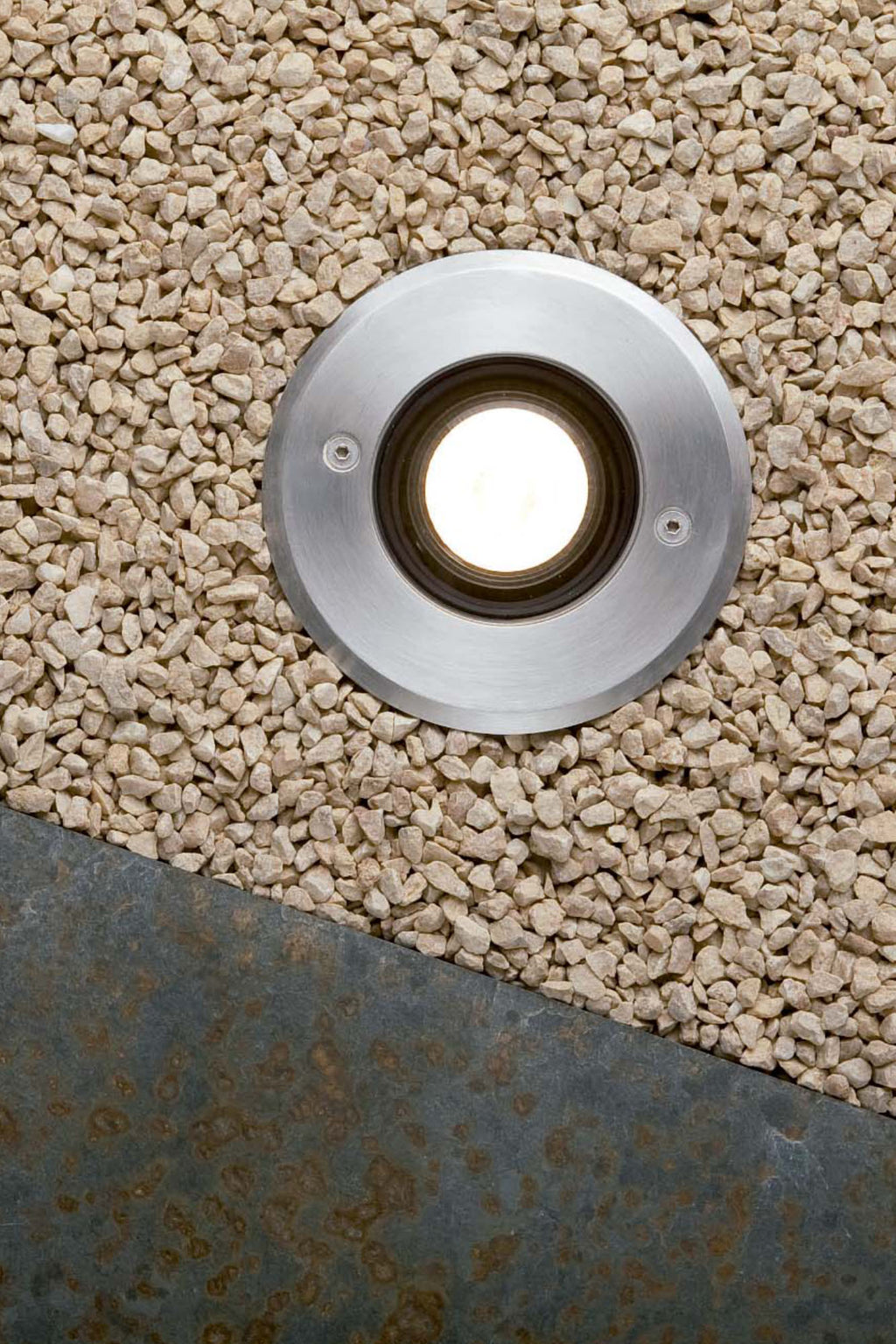 Luz empotrable TECNO Inox de FARO modelo 71489N serie 211 en ambiente de jardín exterior, luminaria empotrable en acero inoxidable con IP67 e IK08 para iluminación de suelos y terrazas.