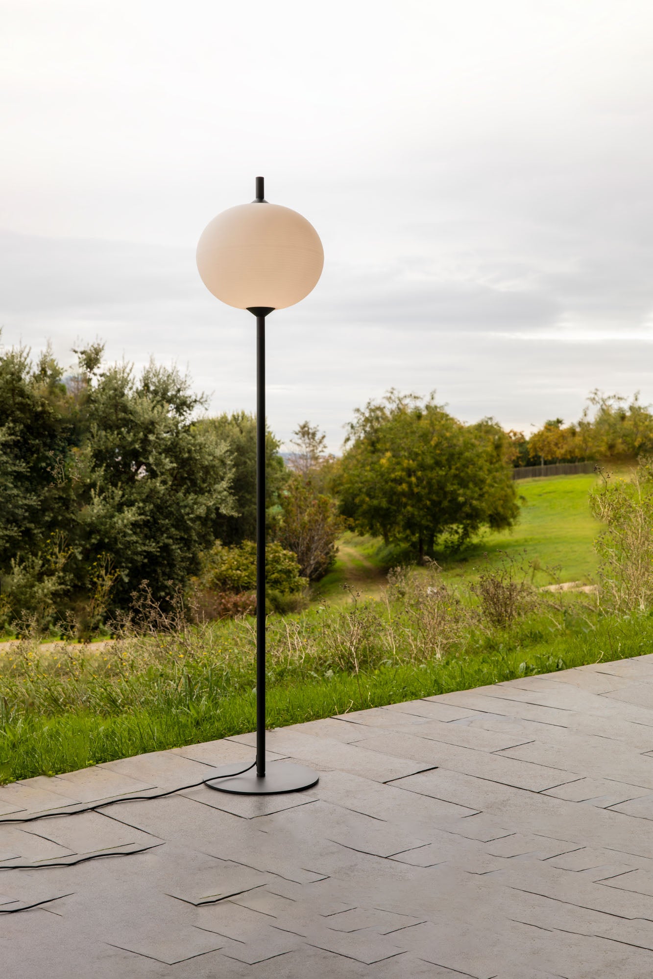 Lámpara de pie exterior SAIGON OUT 2100 R45 gris/blanco mate de FARO en ambiente de jardín, diseño minimalista en aluminio para iluminación jardín