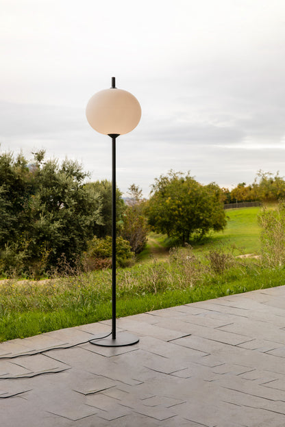 Lámpara de pie exterior SAIGON OUT 2100 R45 gris/blanco mate de FARO en ambiente de jardín, diseño minimalista en aluminio para iluminación jardín