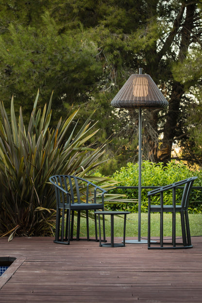Lámpara de pie exterior SAIGON OUT 1950 W70 de FARO en gris y marrón, con estructura de aluminio y mimbre sintético, iluminando un jardín o terraza en ambiente nocturno