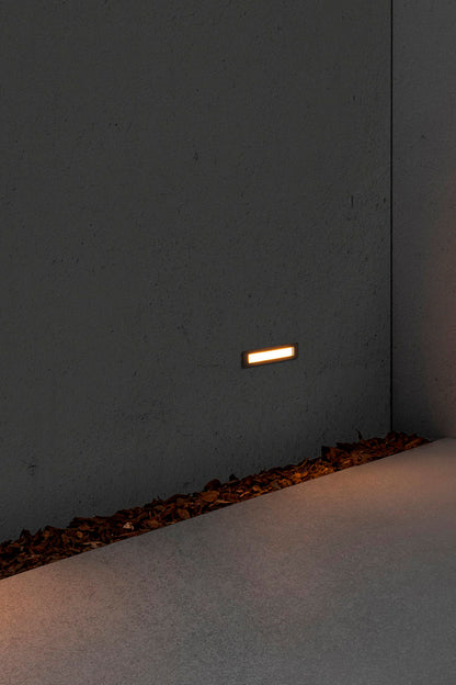 Faro empotrable LED FALLS 290 6W 2700K acero inoxidable IP67 en ambiente de jardín o terraza, luminaria exterior para iluminación cálida en paisajes.