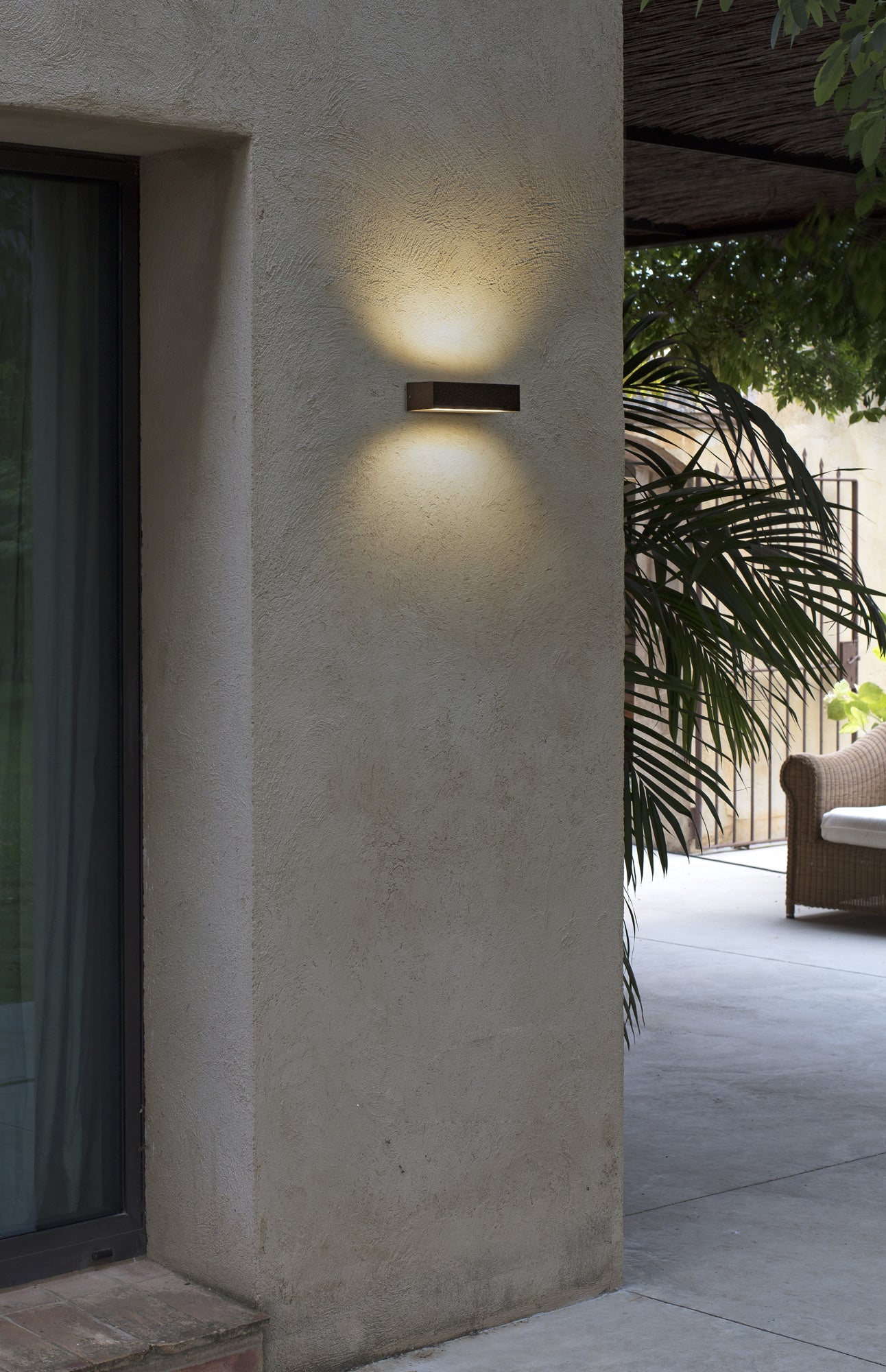 Aplique de pared LED DORO 220 marrón óxido FARO 71902 instalado en fachada exterior de jardín, iluminación cálida 3000K IP65 resistente al agua