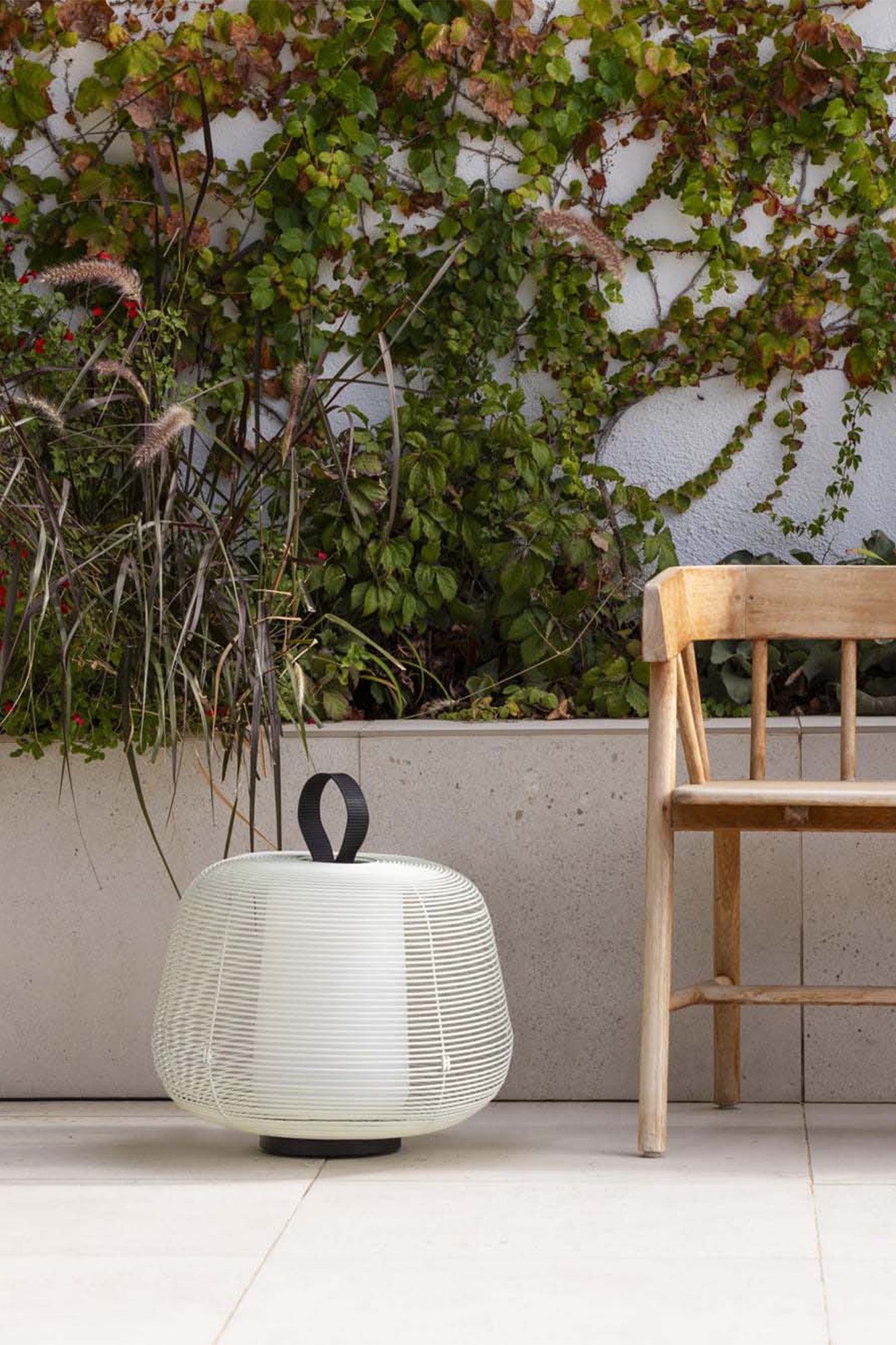 Lámpara portátil NARA Beige FARO 72102-155 en ambiente de jardín exterior, luminaria de superficie en acero IP65 para terraza y jardín