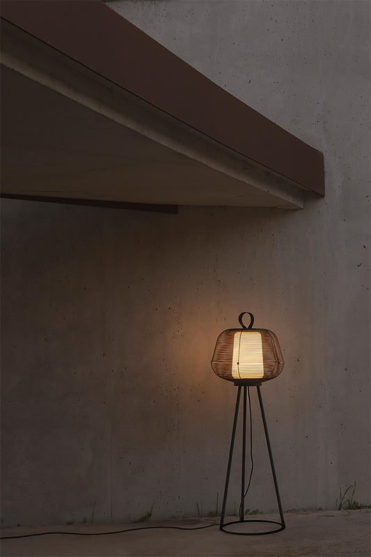 Lámpara de pie NARA negra de FARO modelo 72103-156 en ambiente de jardín exterior, diseño moderno en acero IP65 para iluminación resistente.