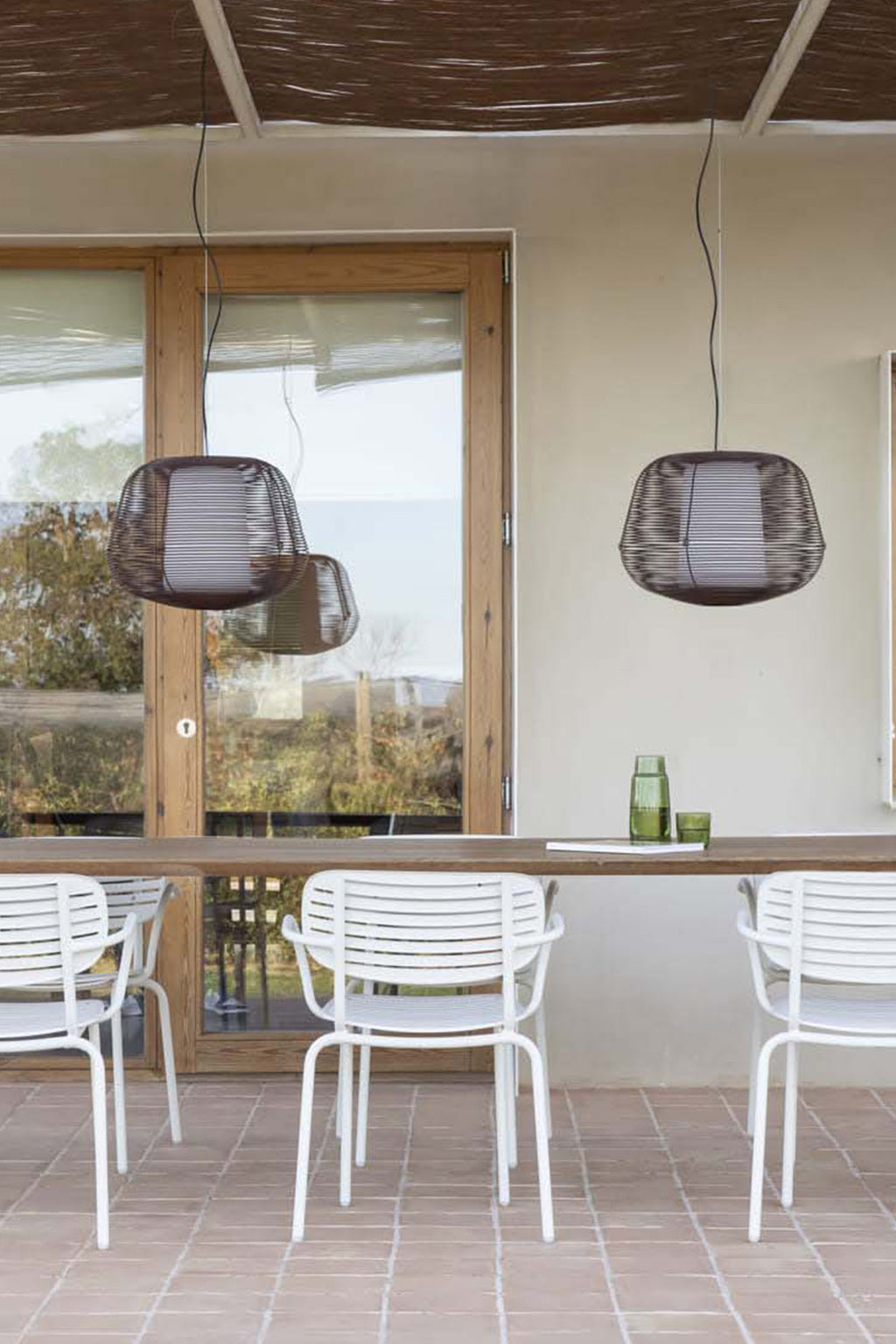 Lámpara colgante NARA marrón óxido de FARO modelo 72104-157 en ambiente exterior, faro de acero IP65 serie 2292 iluminando jardín y terraza con luz cálida.