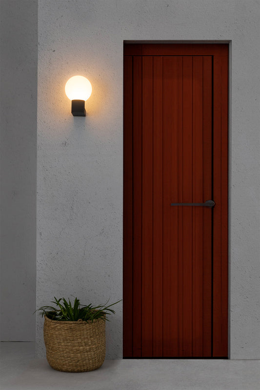 Luminaria de pared exterior MOON en gris oscuro, aplique de aluminio IP44 de FARO (modelo 74432A-01) instalada en entorno de jardín moderno.