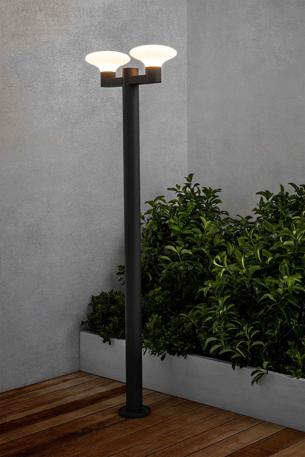 Farola exterior BLUBS 2L en gris oscuro, modelo FARO 74435F2-03, instalada en jardín iluminado, luminaria de superficie en aluminio y PMMA con IP44 para iluminación exterior resistente.