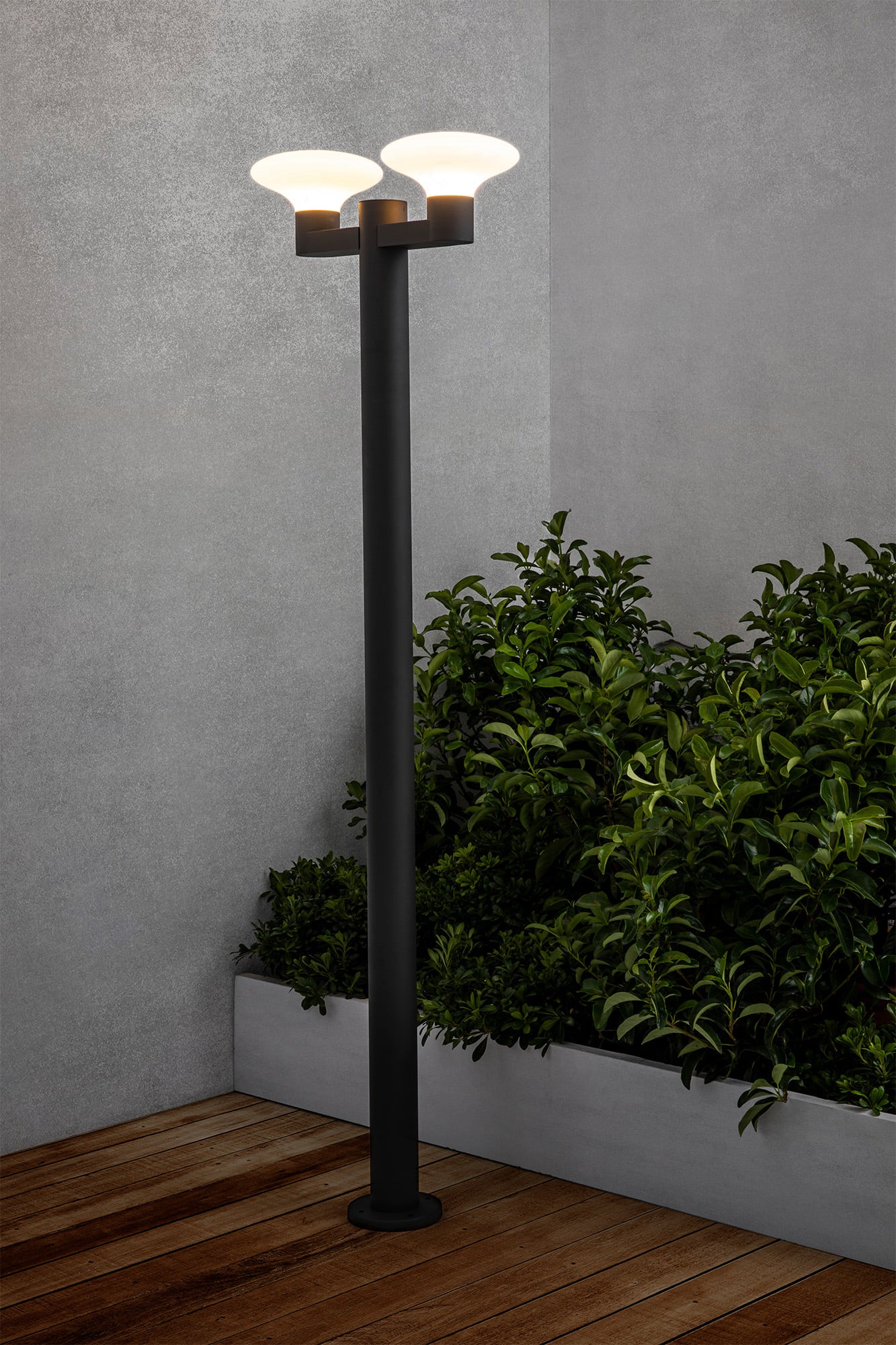 Farola exterior BLUBS 2L en gris oscuro, modelo FARO 74435F2-03, instalada en jardín iluminado, luminaria de superficie en aluminio y PMMA con IP44 para iluminación exterior resistente.