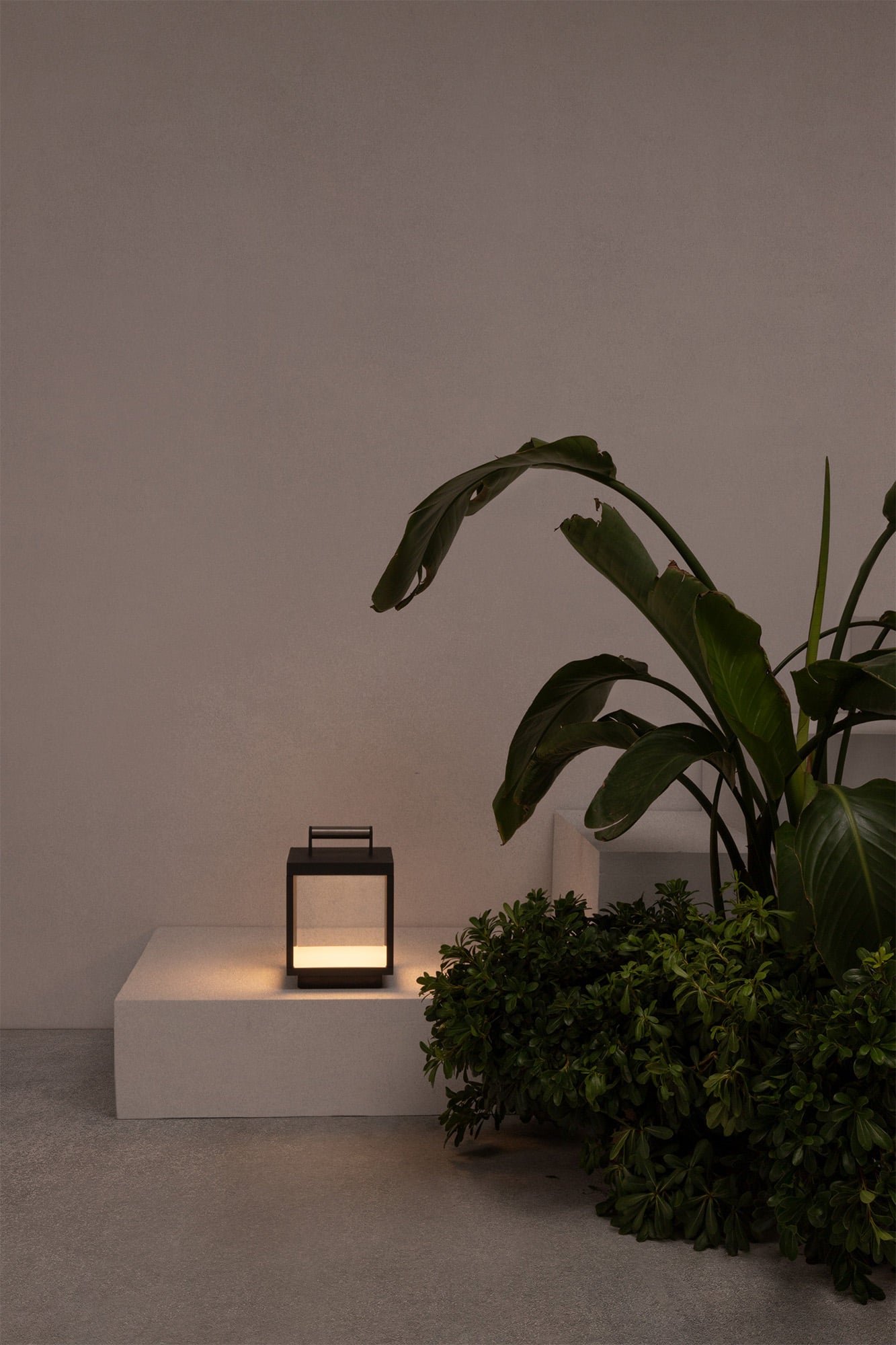 Lámpara portátil KERALA en gris oscuro modelo 74454 de FARO, en ambiente de jardín exterior con iluminación LED regulable, batería recargable y resistencia IP54 para luminaria de superficie