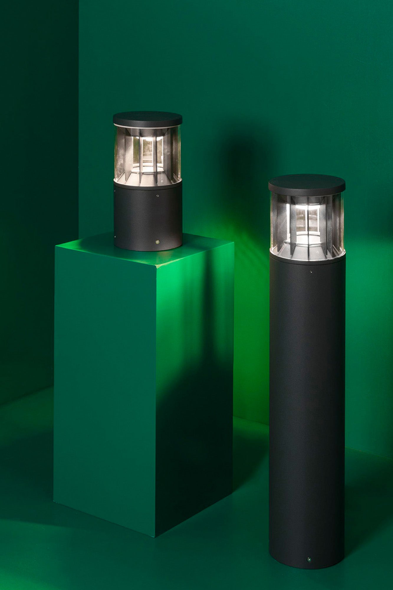 Luminaria exterior SCREEN 250 sobremuro en gris oscuro de FARO modelo 751000, instalada en jardín o parque con iluminación LED 2700K cálida y 360 grados en aluminio PC