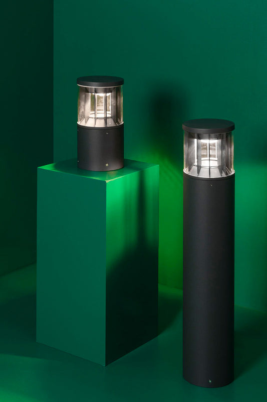 Luminaria exterior SCREEN 250 sobremuro en gris oscuro de FARO modelo 751000, instalada en jardín o parque con iluminación LED 2700K cálida y 360 grados en aluminio PC