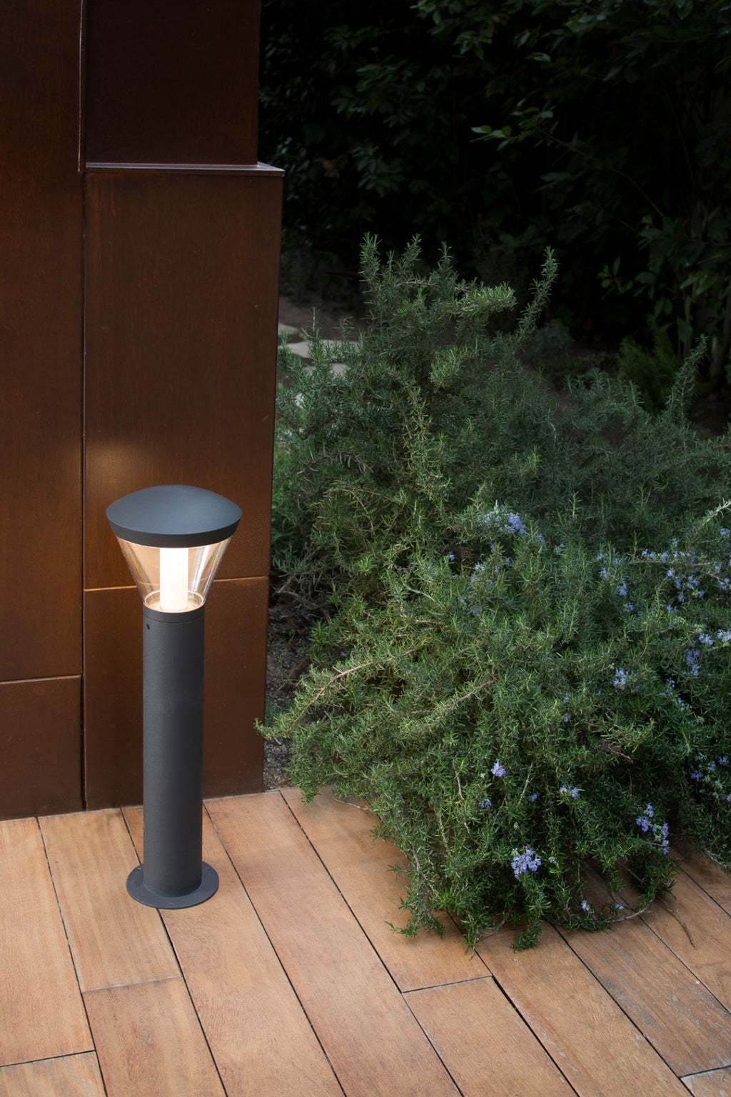 Baliza LED exterior Shelby 630 gris oscuro instalada en jardín, faro moderno de aluminio IP65 para luminaria de superficie e iluminación ambiental.