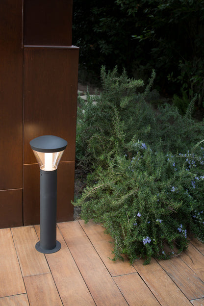 Baliza LED exterior Shelby 630 gris oscuro instalada en jardín, faro moderno de aluminio IP65 para luminaria de superficie e iluminación ambiental.