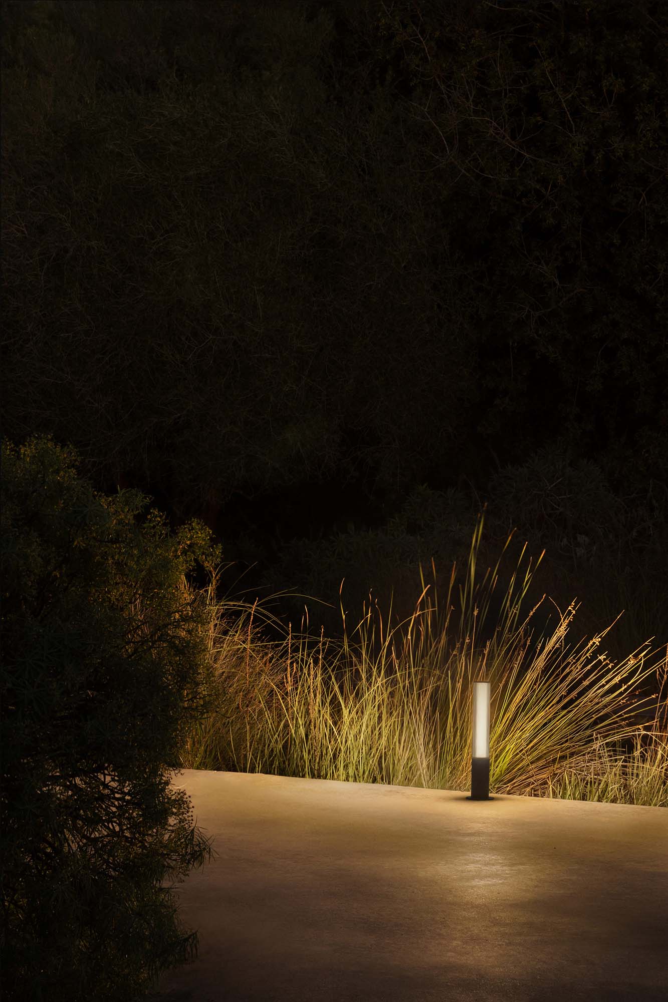 Baliza exterior TURA 650 gris oscuro en imagen ambiente de jardín, faro LED de aluminio IP65 serie 75545 para iluminación exterior superficial