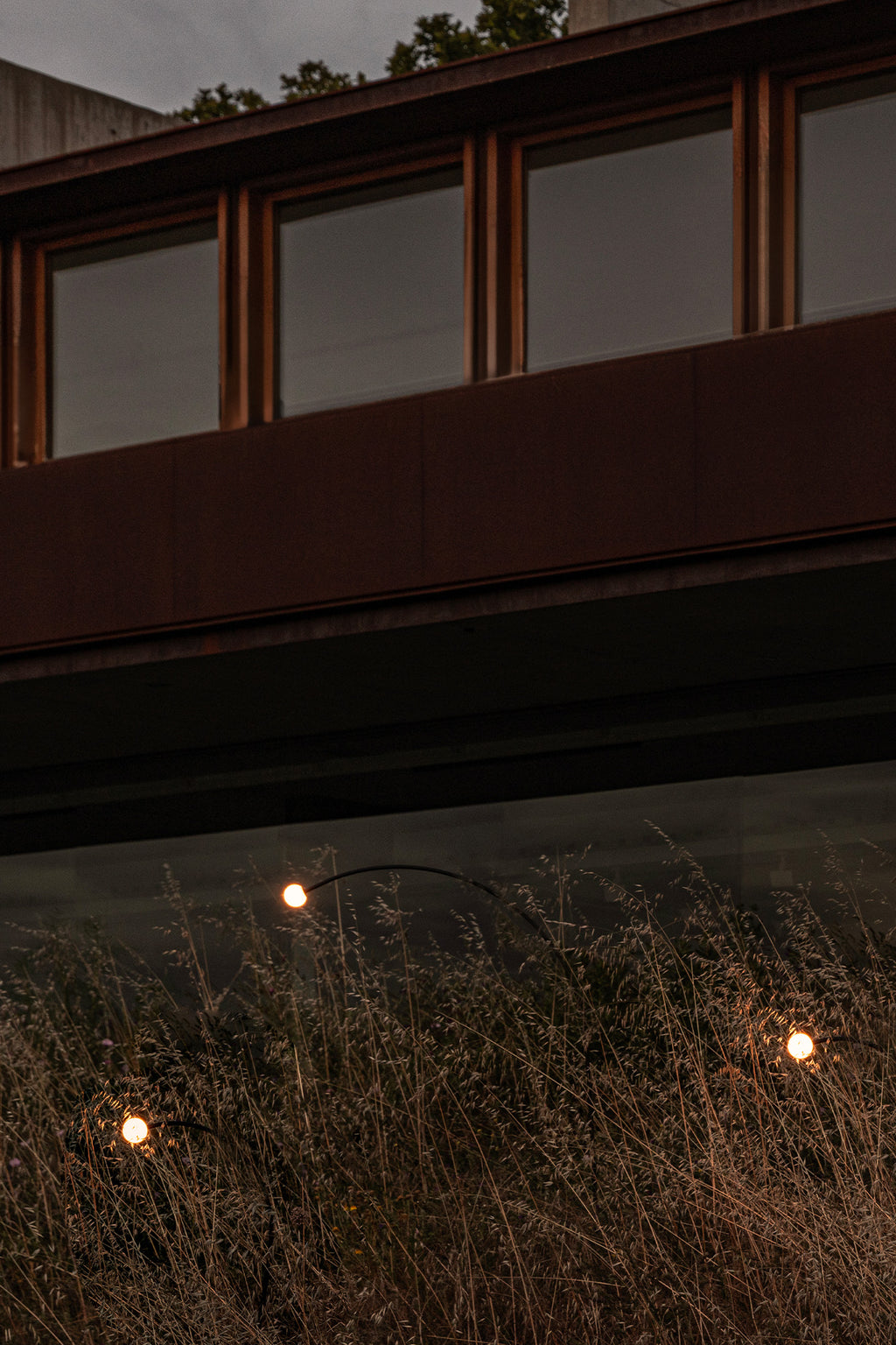 Estaca exterior CUCA 1193 negra 24V FARO 75562 en jardín minimalista, luminaria LED de acero inoxidable para iluminación exterior