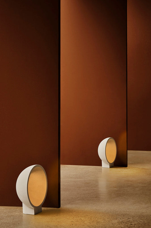 Baliza exterior GAIA beige de FARO (modelo 75564) en ambiente de jardín, luminaria LED IP55 de cemento con diseño orgánico para iluminación exterior.