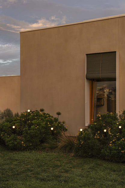 Estaca exterior CUCA 1000 negra de FARO en imagen ambiente de jardín iluminado, luminaria LED de superficie en acero inoxidable IP65 para paisajismo y diseño exterior