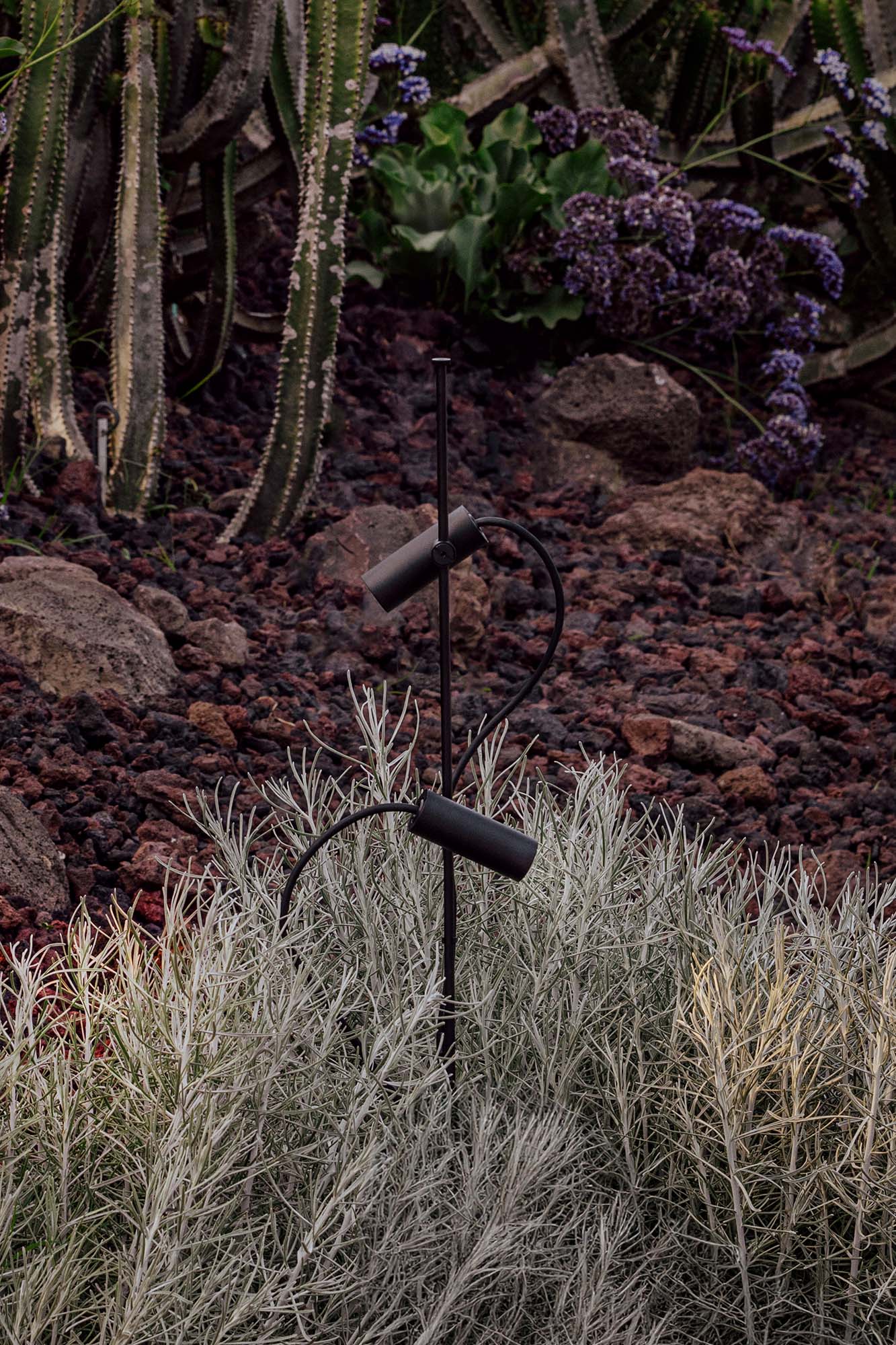 Proyector LED exterior CLAP negro 6W 3000K 38° FARO 75702-233 en ambiente de jardín, luminaria superficie IP65 aluminio para terraza e iluminación escenográfica