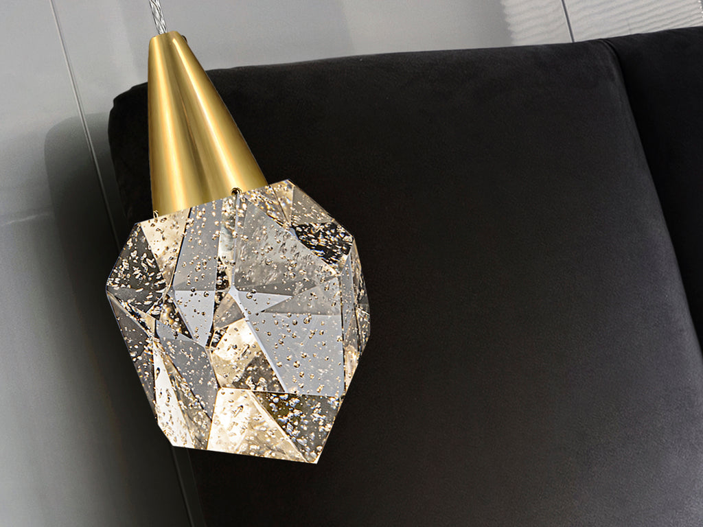 Lámpara colgante Aquaria oro mate de Schuller iluminando un comedor moderno, con diseño de cristal y tecnología LED regulable en altura, ideal para salón.