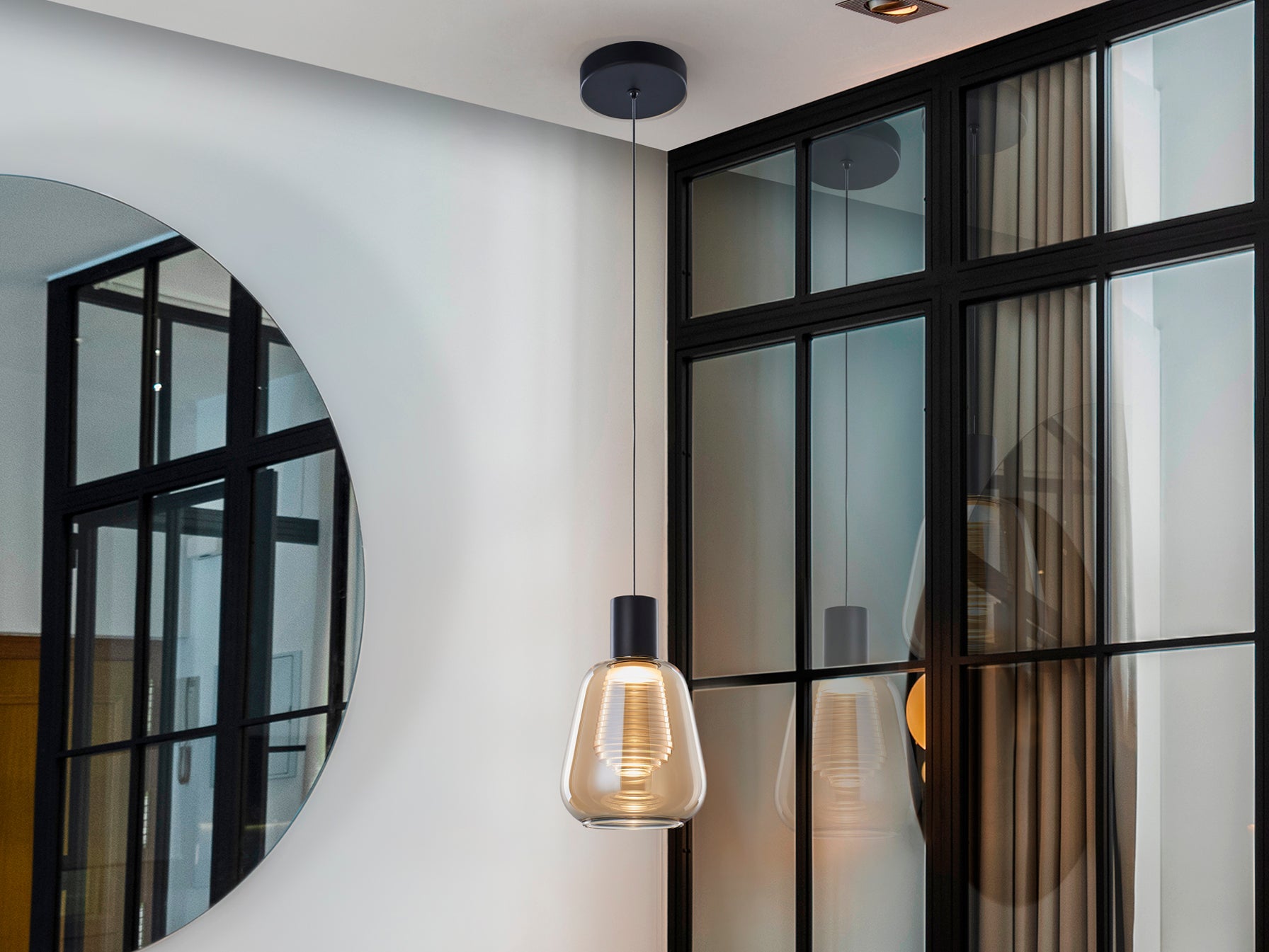 Lámpara colgante Carisa negro y ámbar de Schuller (341017) en comedor moderno, con diseño de cristal y metal, iluminación LED regulable en altura para salón.