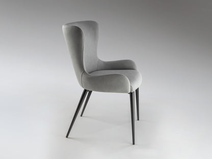 Silla Telma Gris Claro Schuller, diseño nórdico con tapizado, patas de metal negro mate, ideal para comedor moderno.