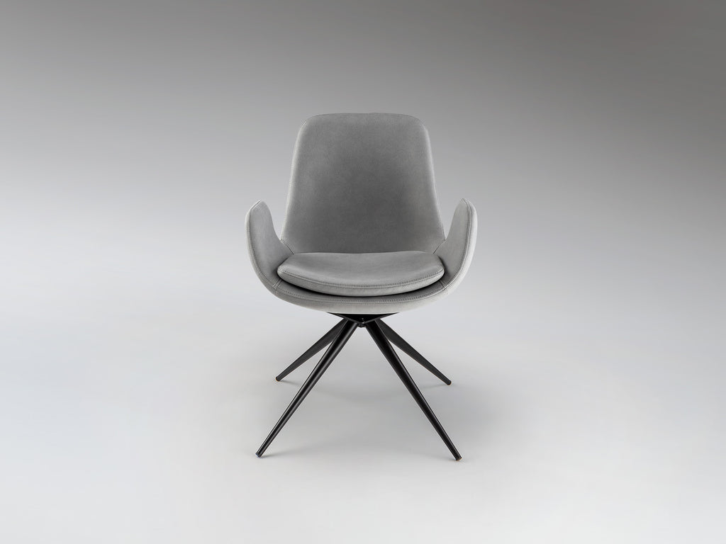 Silla giratoria Zuna gris claro Schuller en comedor moderno, con estructura de metal negro mate y tapizado textil. Ideal como silla de oficina.