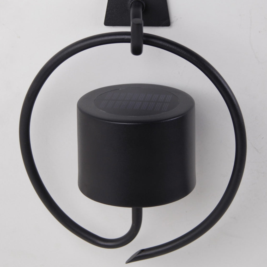 Aplique solar Bolano negro instalado en pared exterior - Ambiente jardín