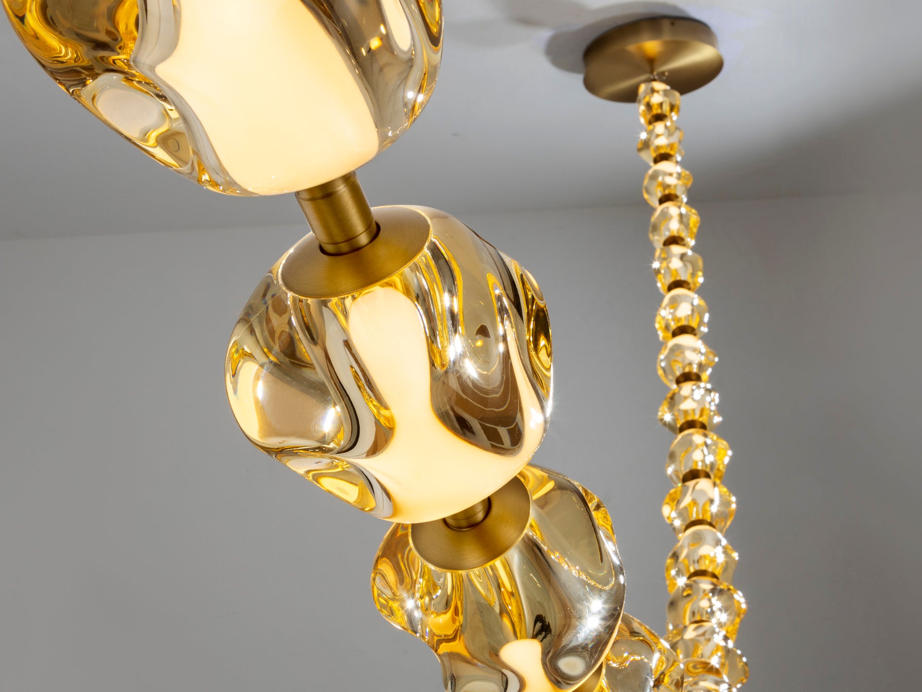 Lámpara de techo LED Schuller Zaria II (448765) - Detalle de su acabado en bronce y 21 tulipas de acrílico ámbar. Iluminación moderna y regulable.
